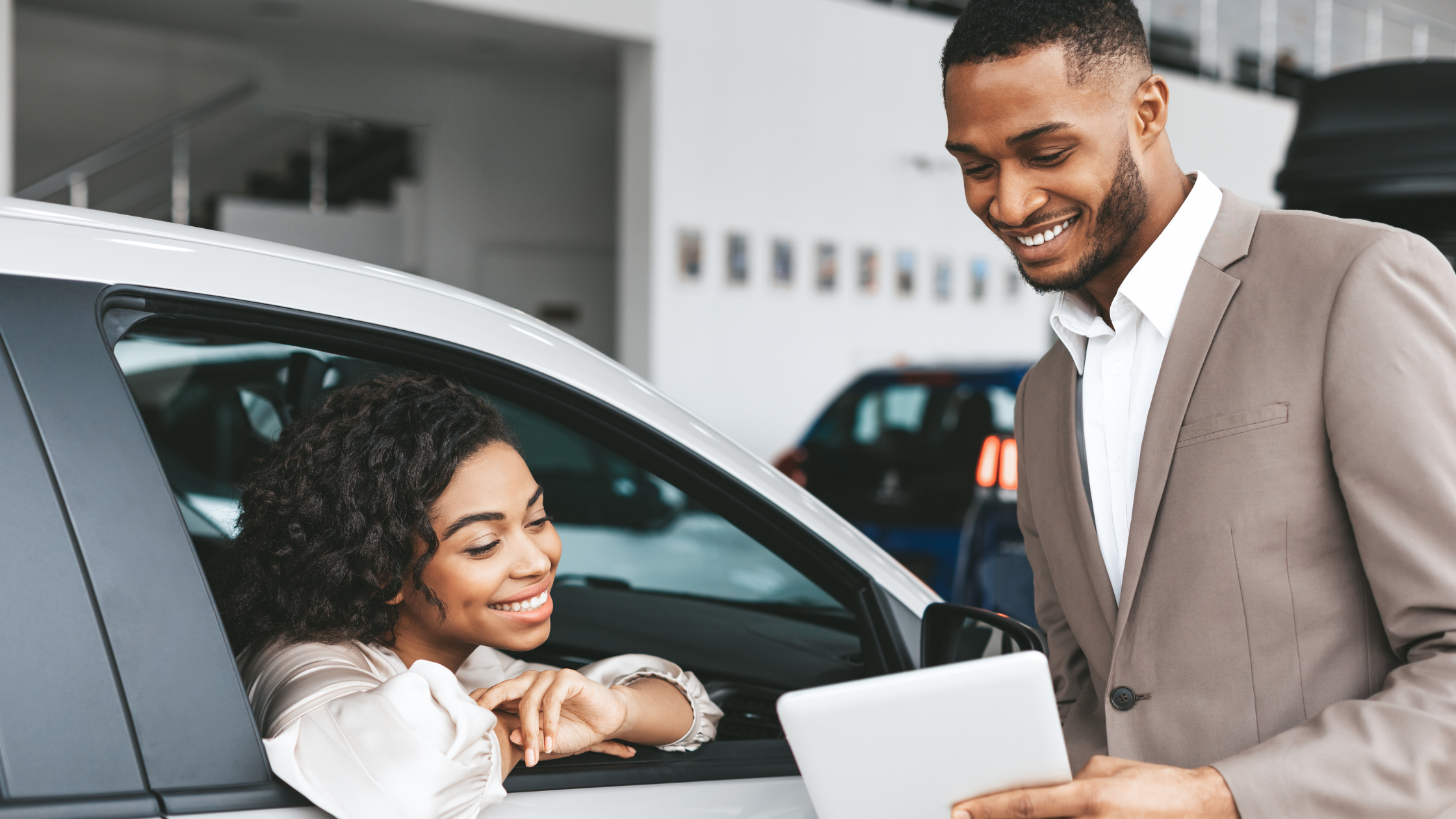 Auto dealership sales man working with customer